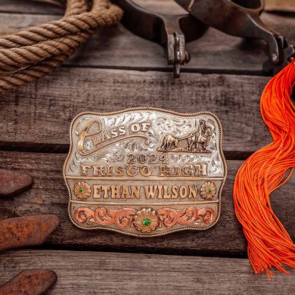 A custom class belt buckle for Frisco High School with personalized name featuring a golden bronze team roping figure 